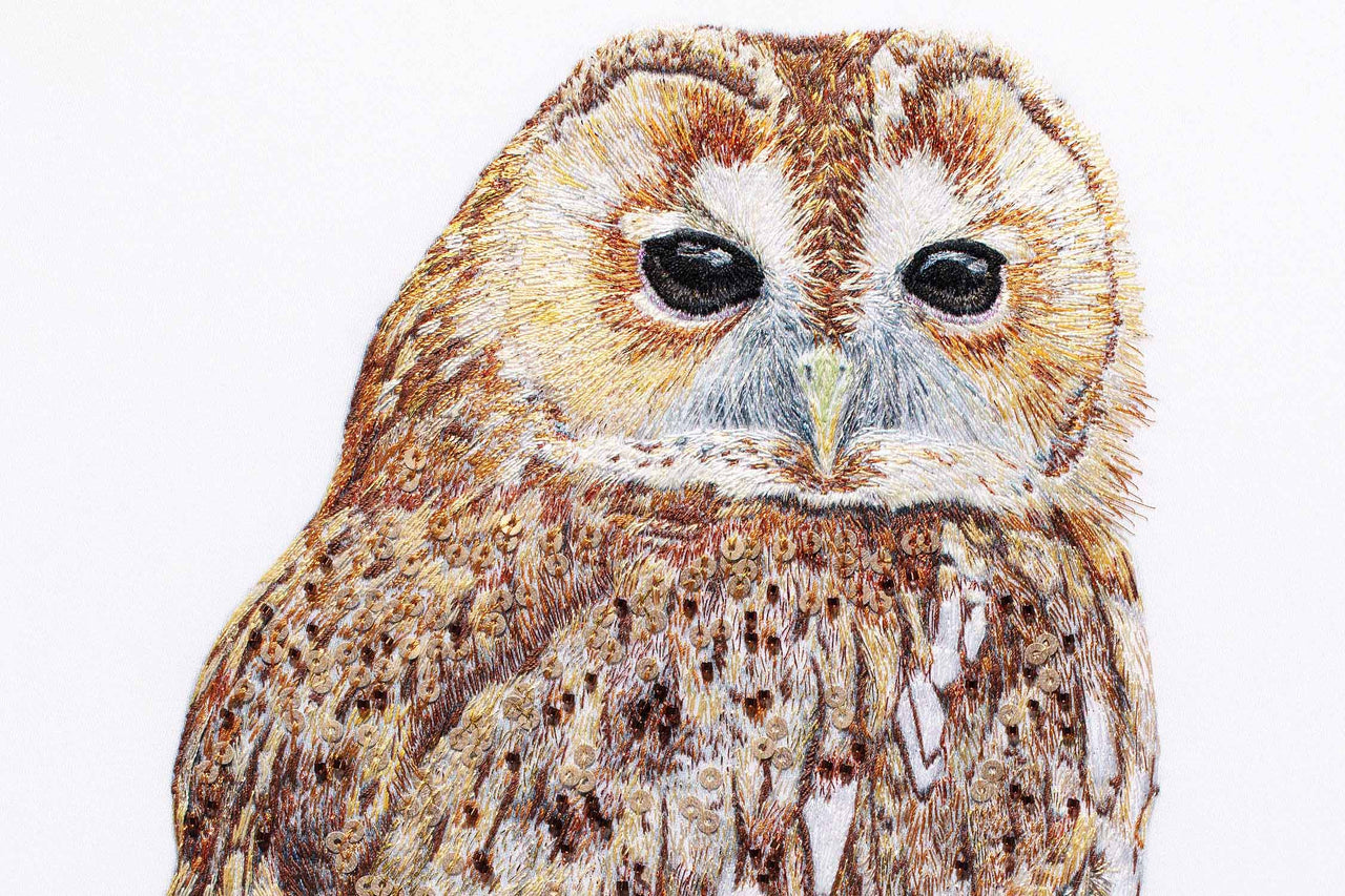 Owl hand embroidered artwork close up.