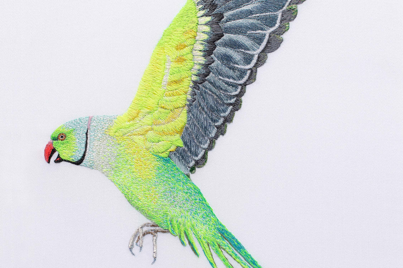 Flying parakeet hand embroidered artwork.