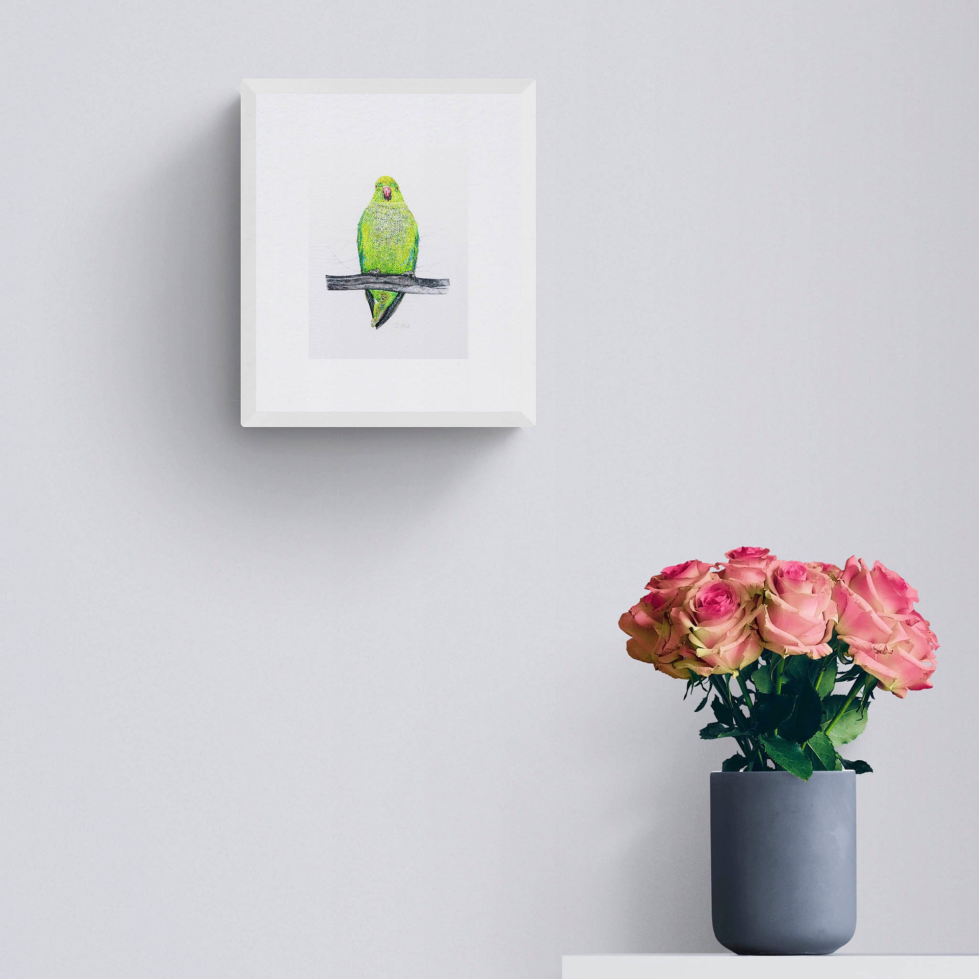 Hand embroidered parakeet framed on wall
