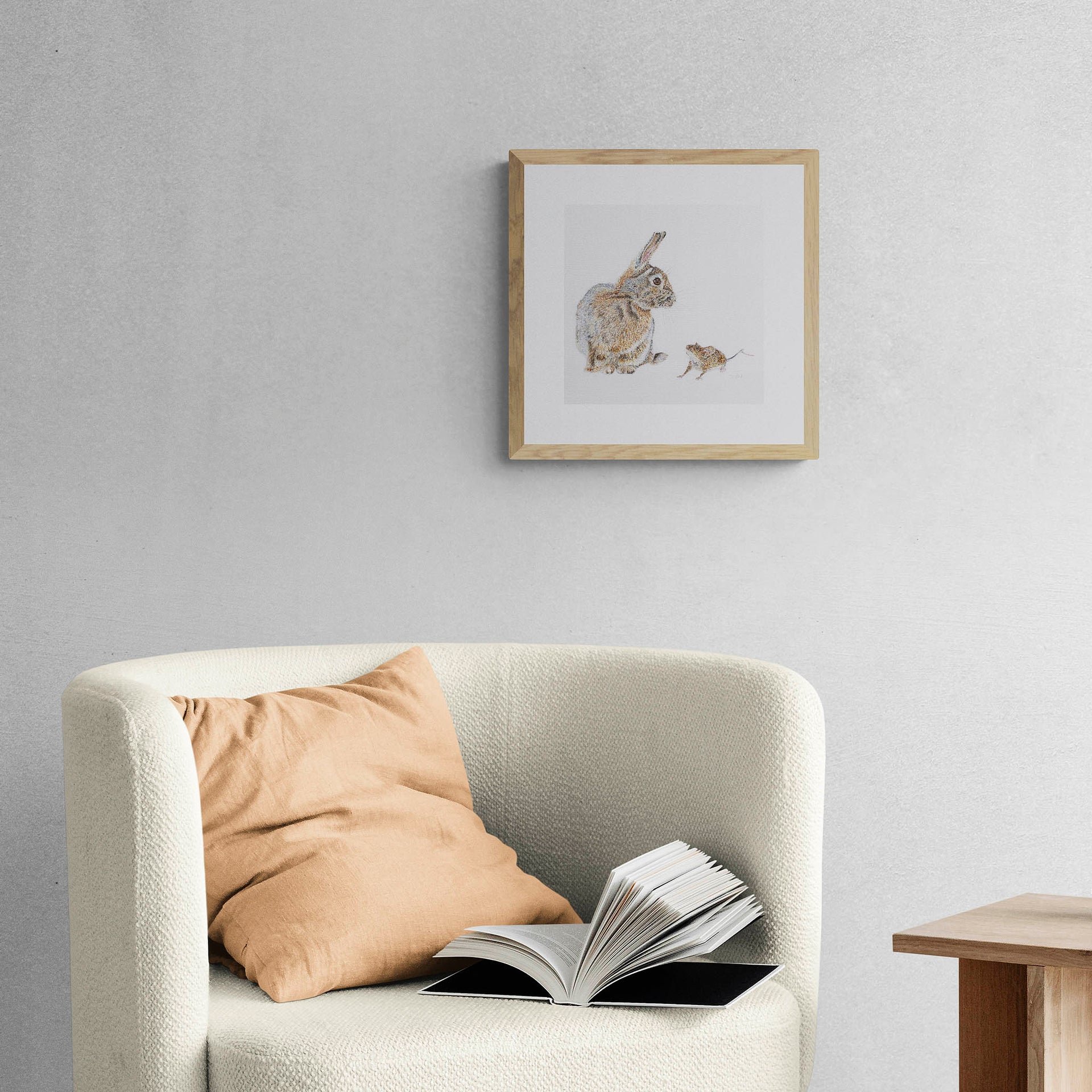 Hand embroidered rabbit and mouse artwork in wooden frame on wall