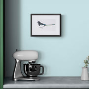 Hand embroidered magpie limited edition print in black frame on the wall