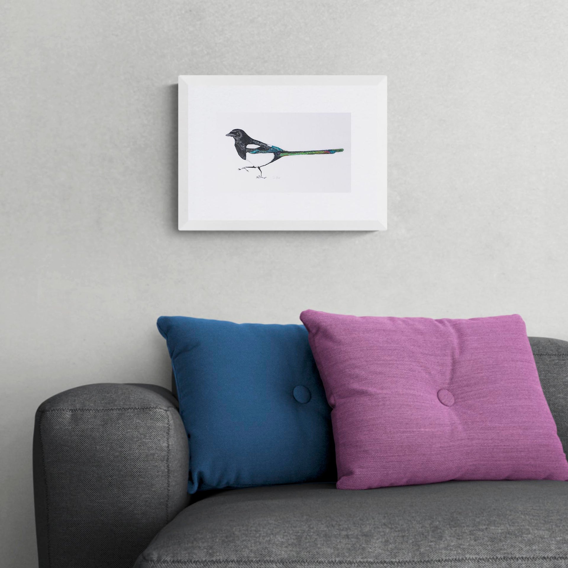 Hand embroidered magpie limited edition print in white frame on the wall