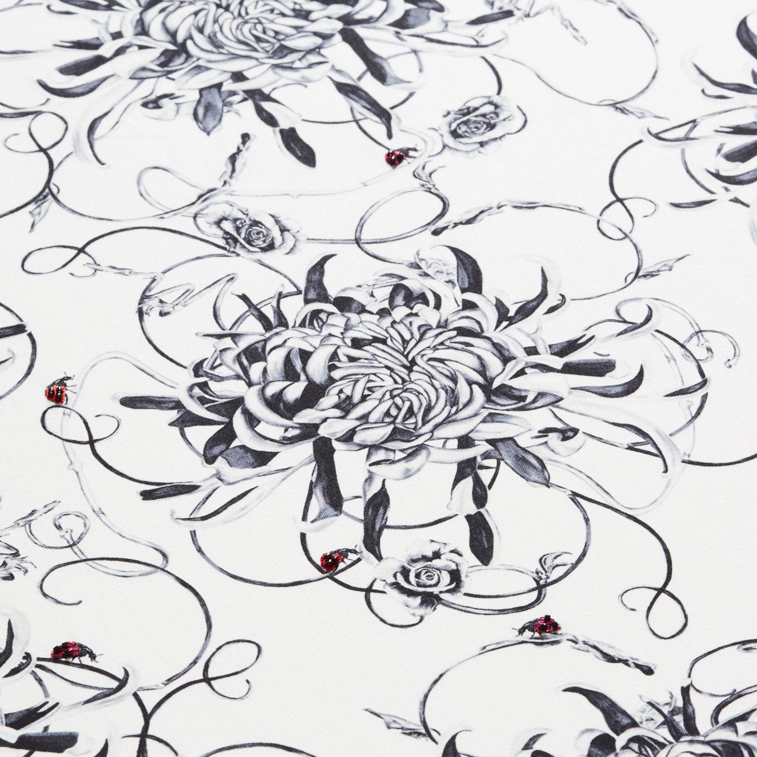 Monochrome floral bolster cushion with hand embroidered ladybirds cushion close up