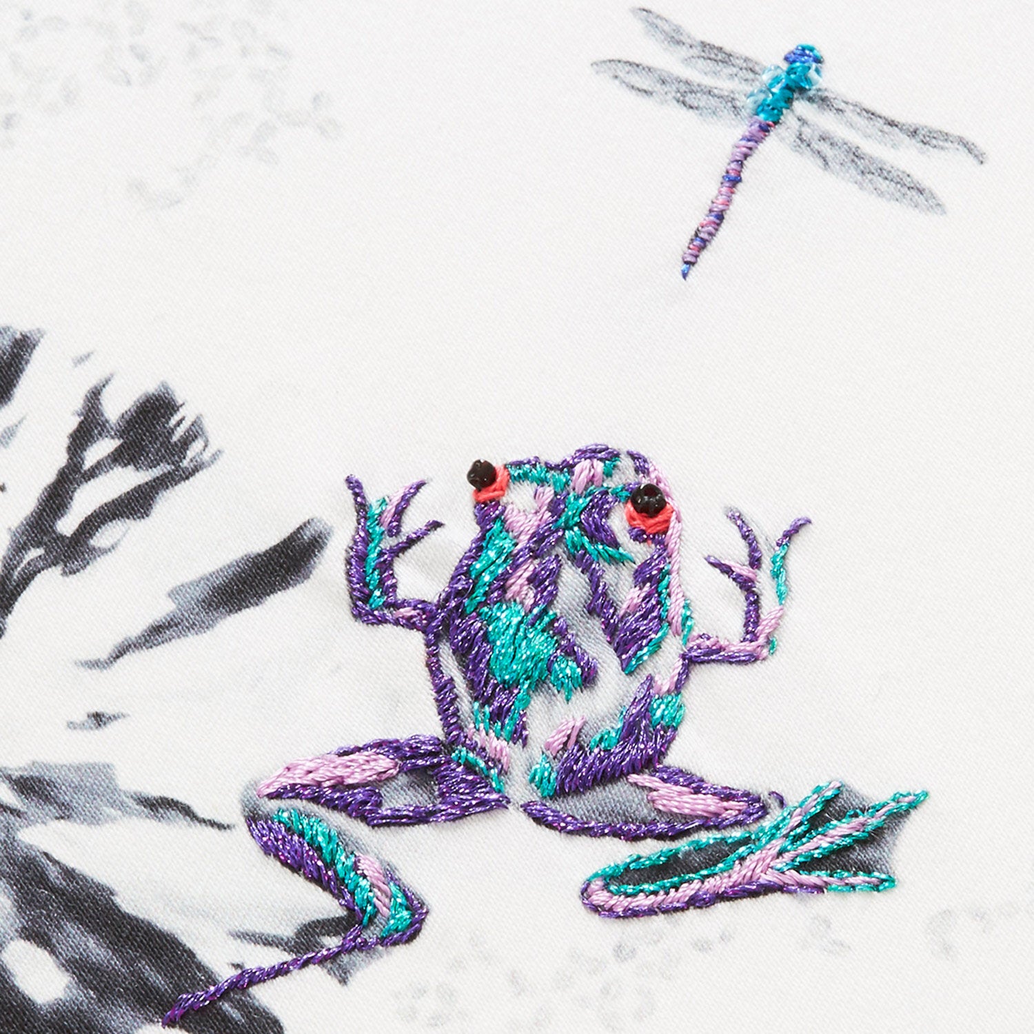 Botanical cushion with hand embroidered frogs and fish close up