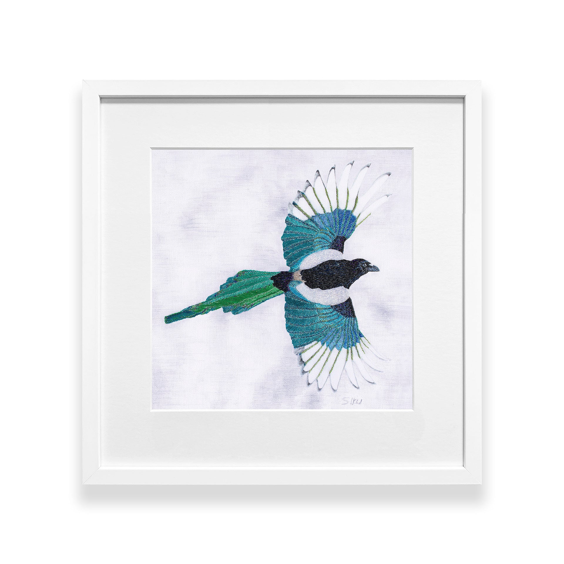 Hand embroidered flying Magpie artwork in white frame