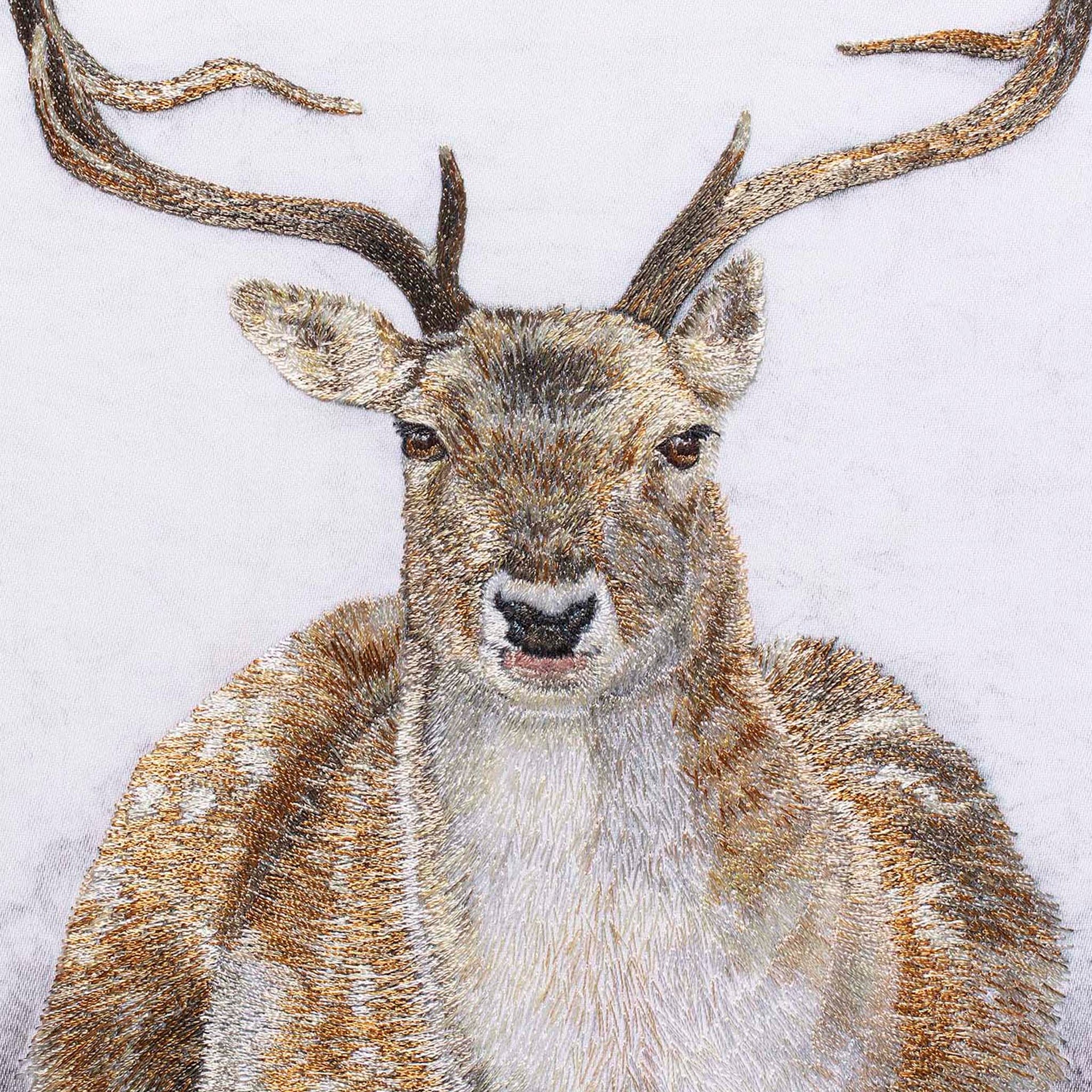 Sitting deer hand embroidered wall art close up.