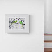 Hyde Park Parakeets limited edition embroidery art print by Susannah Weiland, shown in a white frame with white mount hung on a white wall next to a staircase, demonstrating the print's impact in a clean contemporary interior.