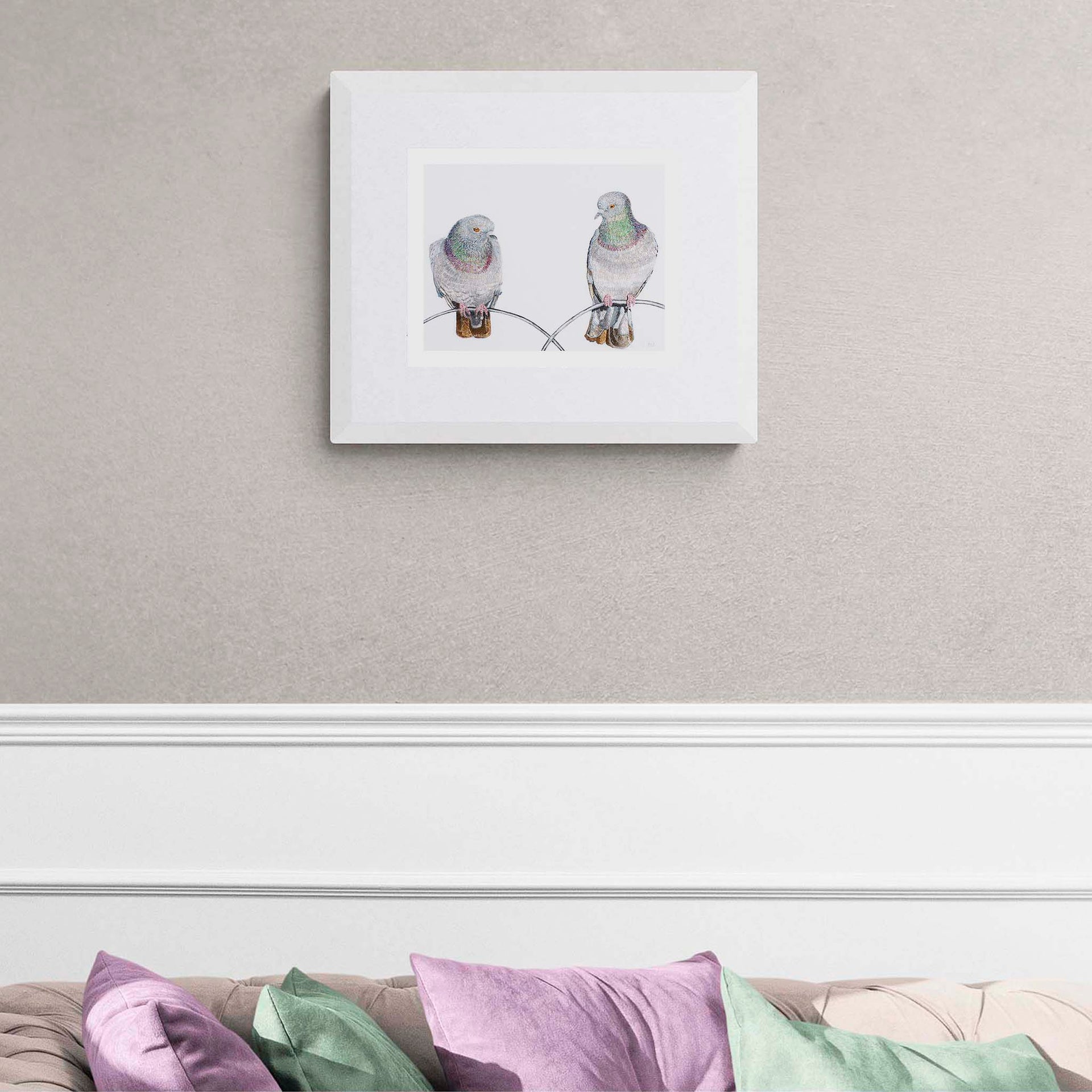Contemporary textile art print of Regent's Park pigeons by Susannah Weiland, shown in a white frame on a cream wall above a sofa with coloured cushions — limited edition of 50.
