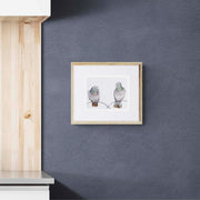 Regent Pigeons luxury embroidered artwork print by Susannah Weiland displayed in a natural pine frame against a dark charcoal textured wall in a contemporary interior.