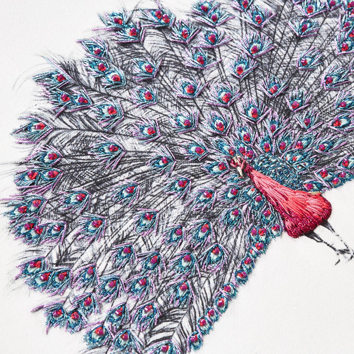 Pink peacock hand embroidered artwork close up