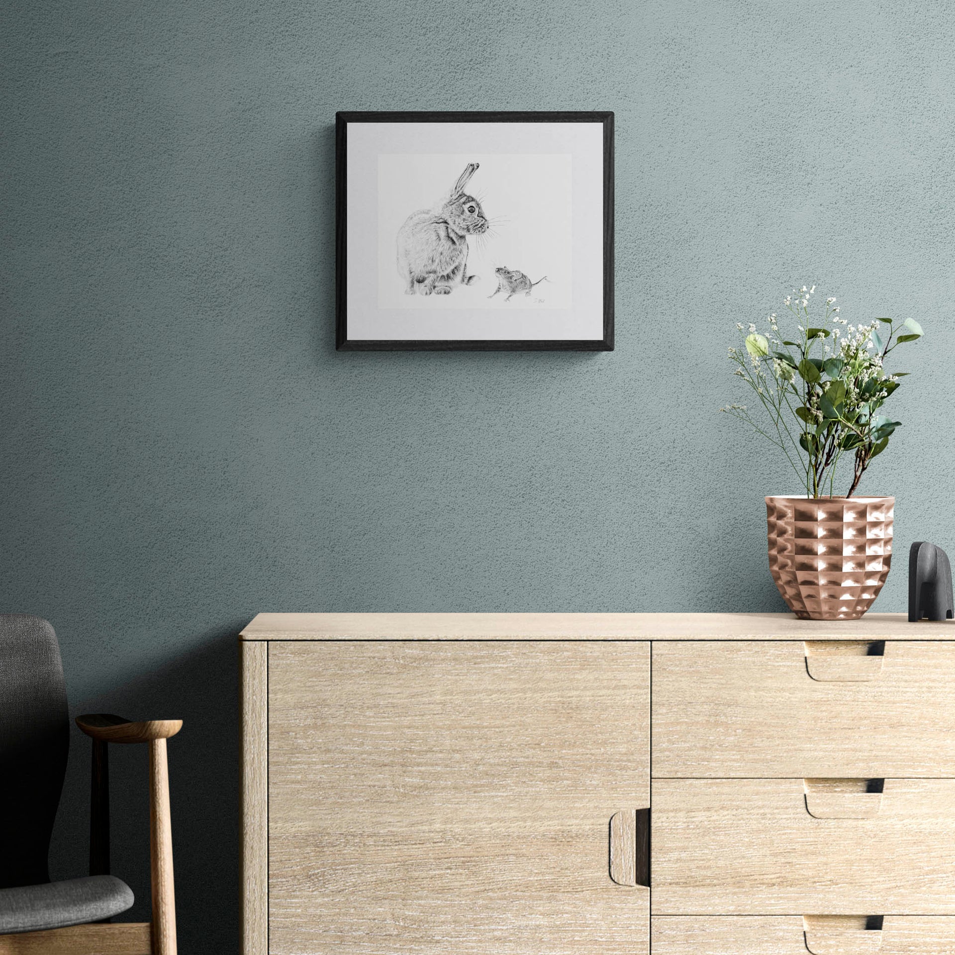 Rabbit and mouse drawing in black frame on wall