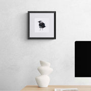 Limited edition print of hand embroidered bird with beads and sequins in black frame on the wall