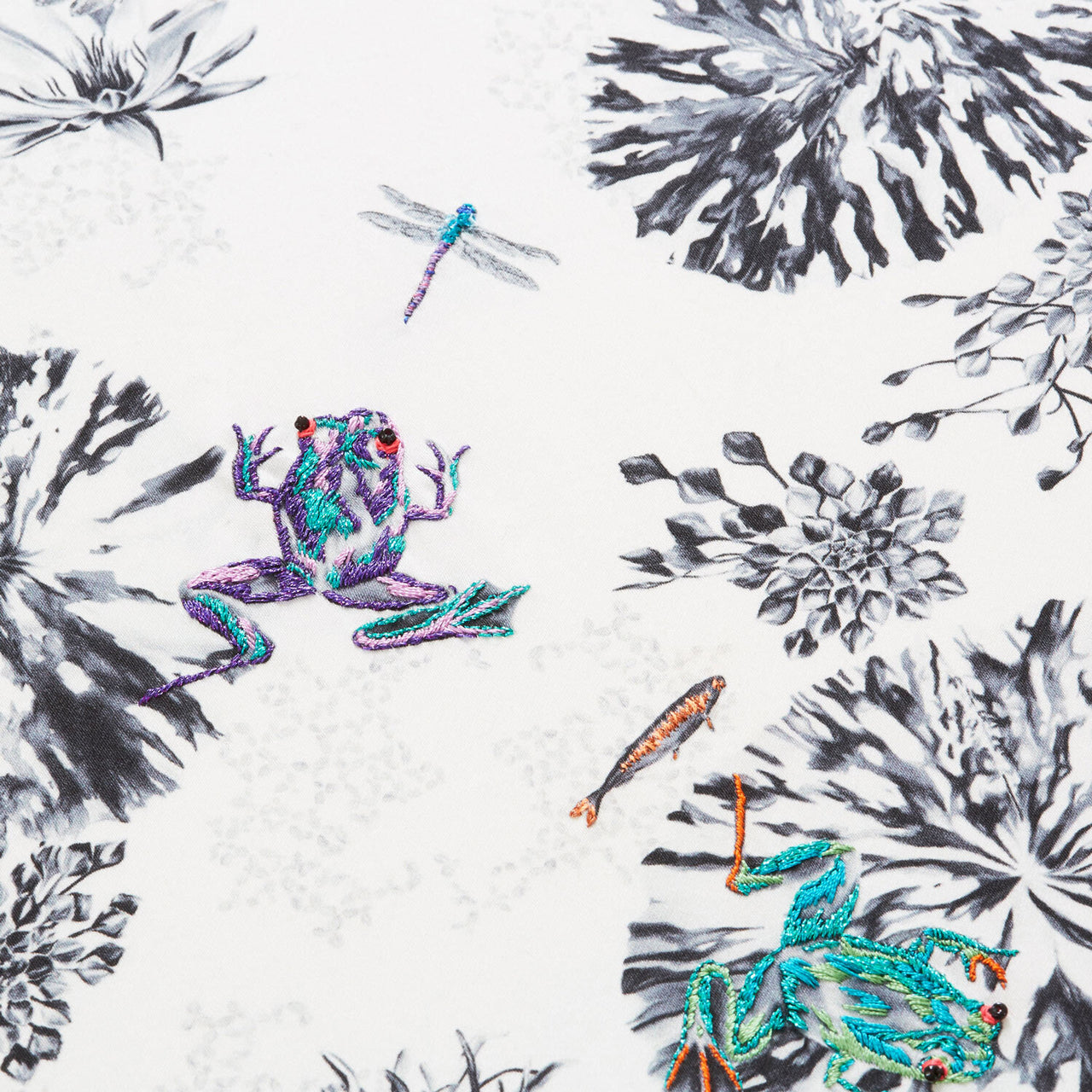 Botanical cushion with hand embroidered frogs and fish close up