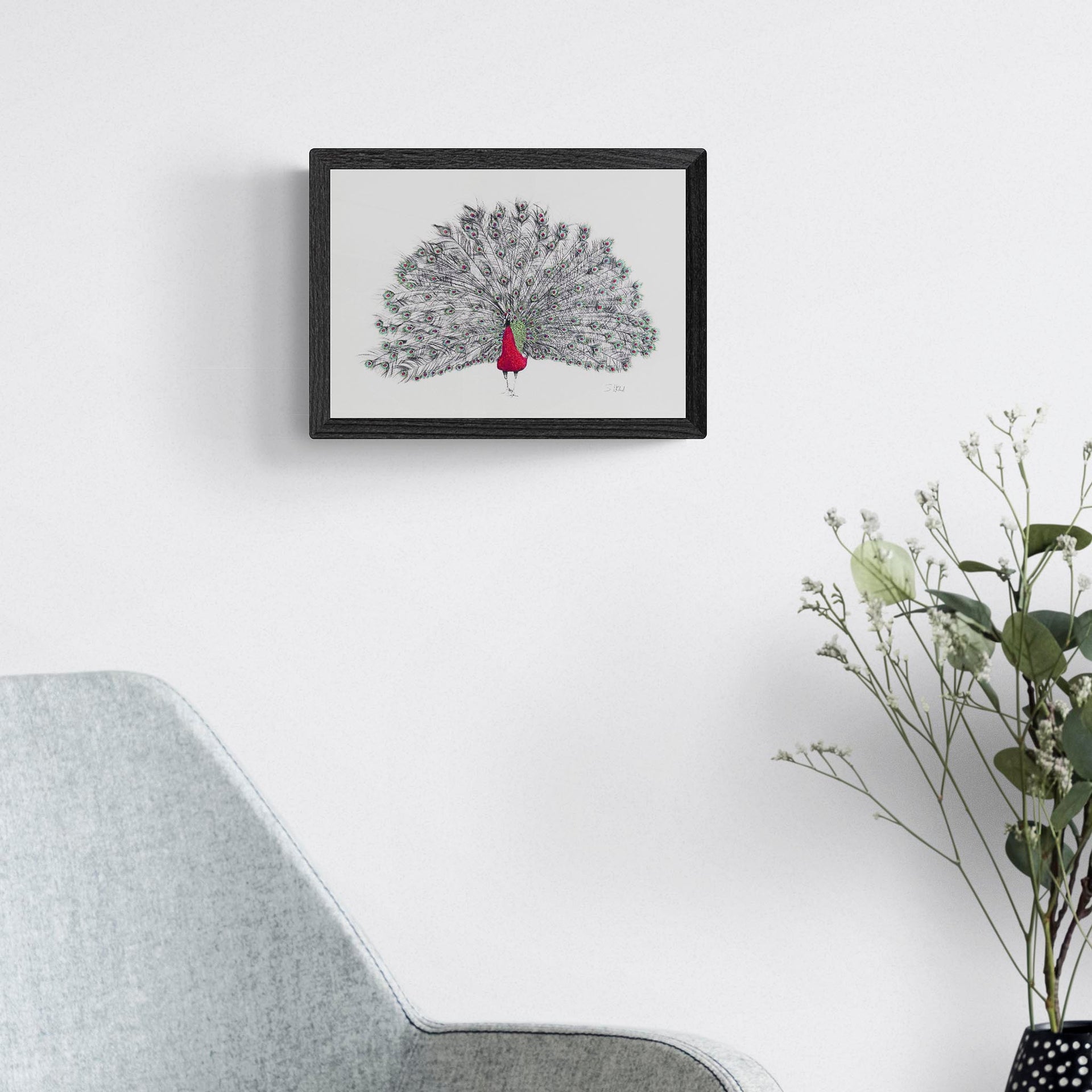 Peacock hand embroidered limited edition print in black frame on the wall